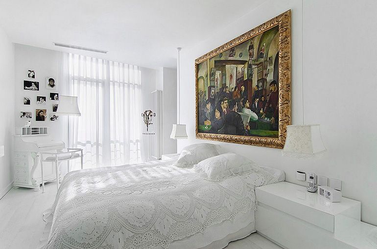 интерьер белой спальни с большой картиной на стене